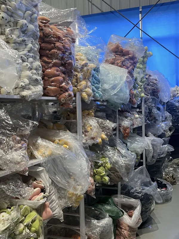 Plush products in different colours are grouped in clear bags and stored on multi-level shelving.